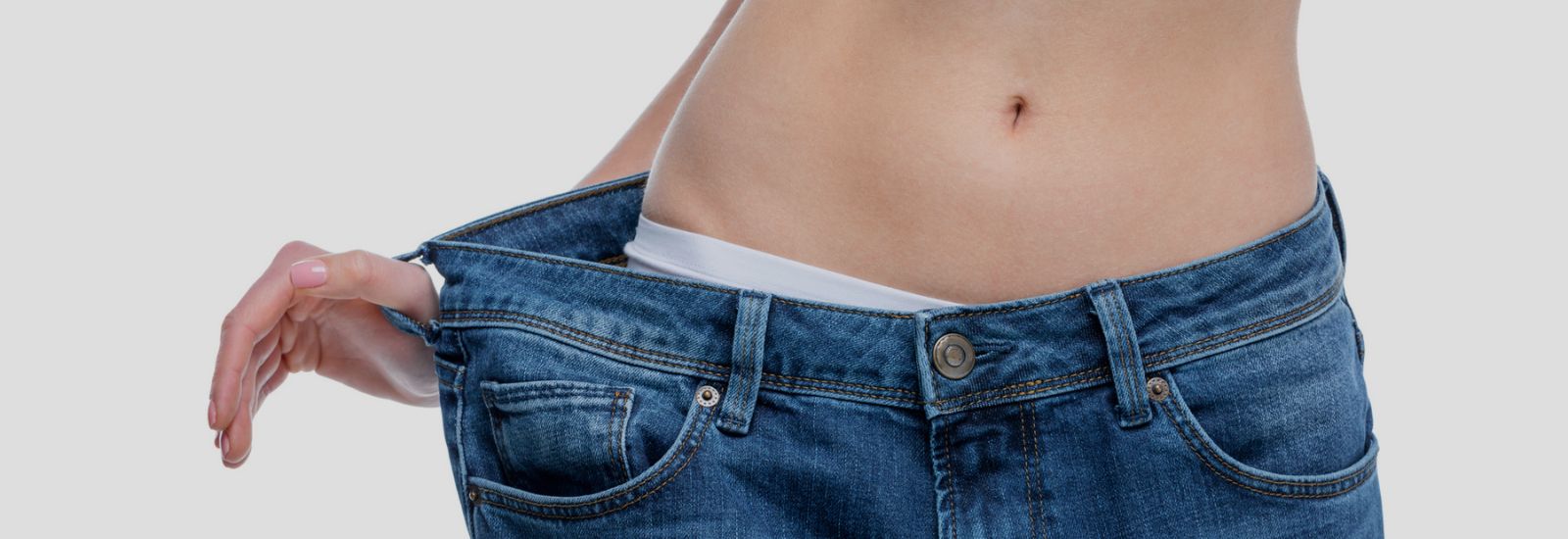 A person is wearing jeans and has their stomach in the pocket.