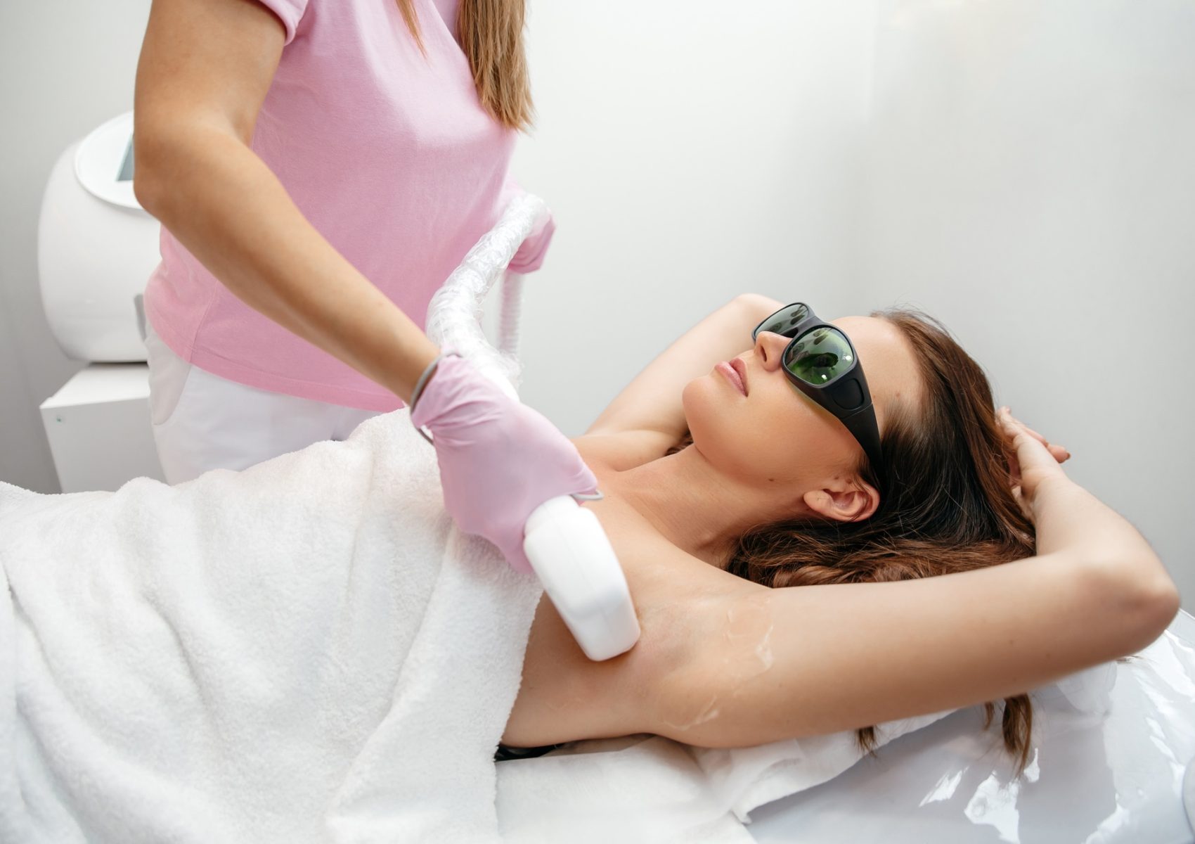 Hair removal by laser hair removal. Caucasian young woman lies on the couch with protective glasses